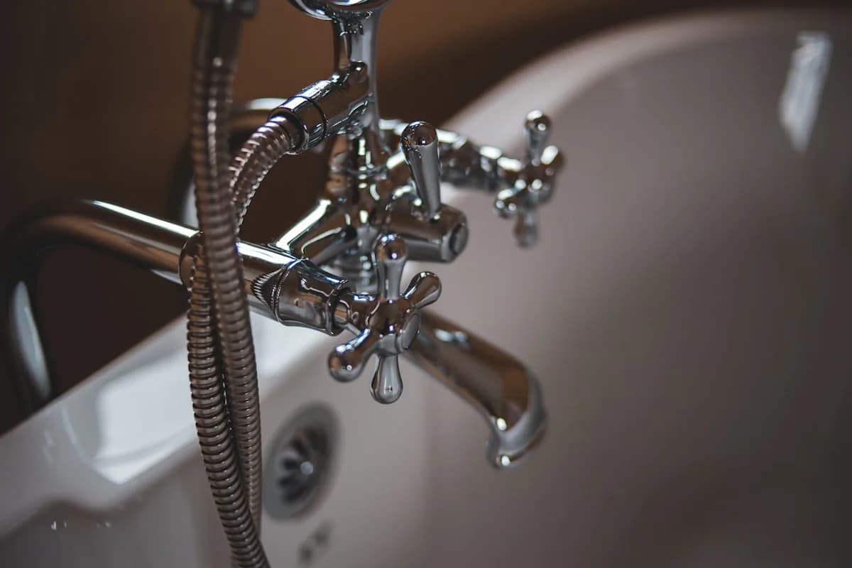 Precision Plumbing technician performing under-sink pipe repair in a modern home